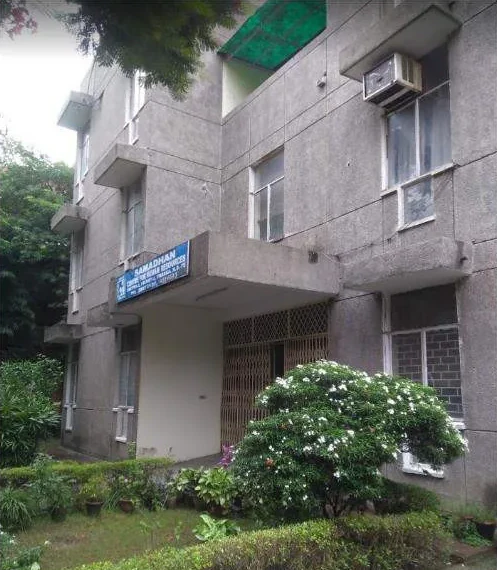 The SAMADHAN building in Dwarka with a flowering shrub