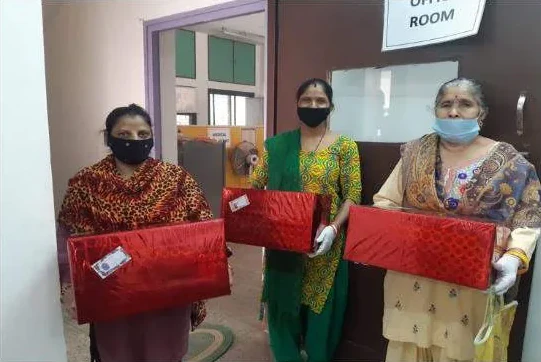 Three women holding red gift boxes