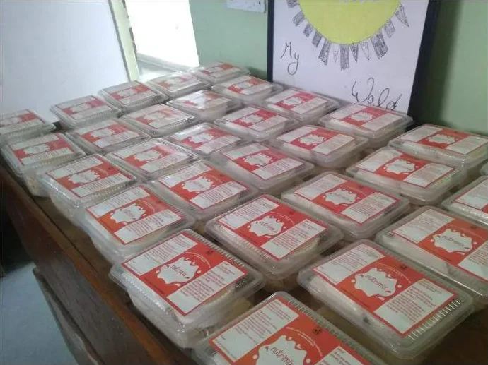 Rows of packed laddoo boxes on a table