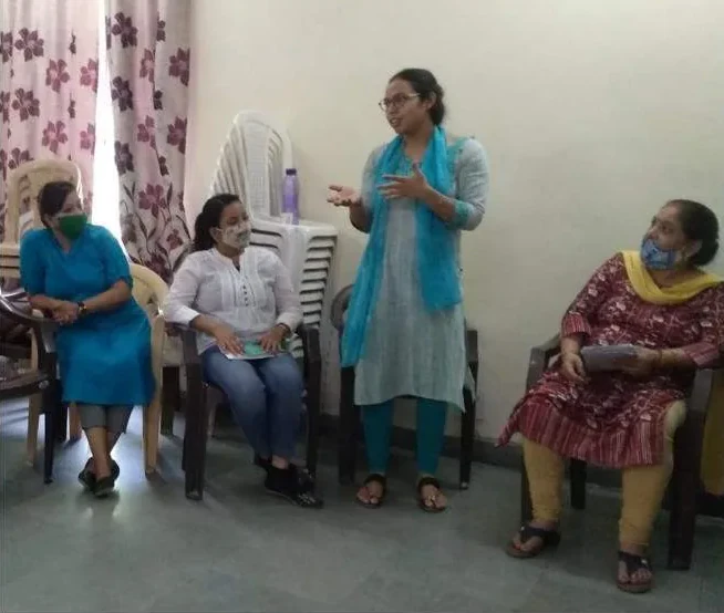 A counsellor standing and talking with seated mothers
