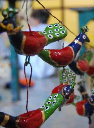 Brightly painted papier-mâché birds hanging on a string
