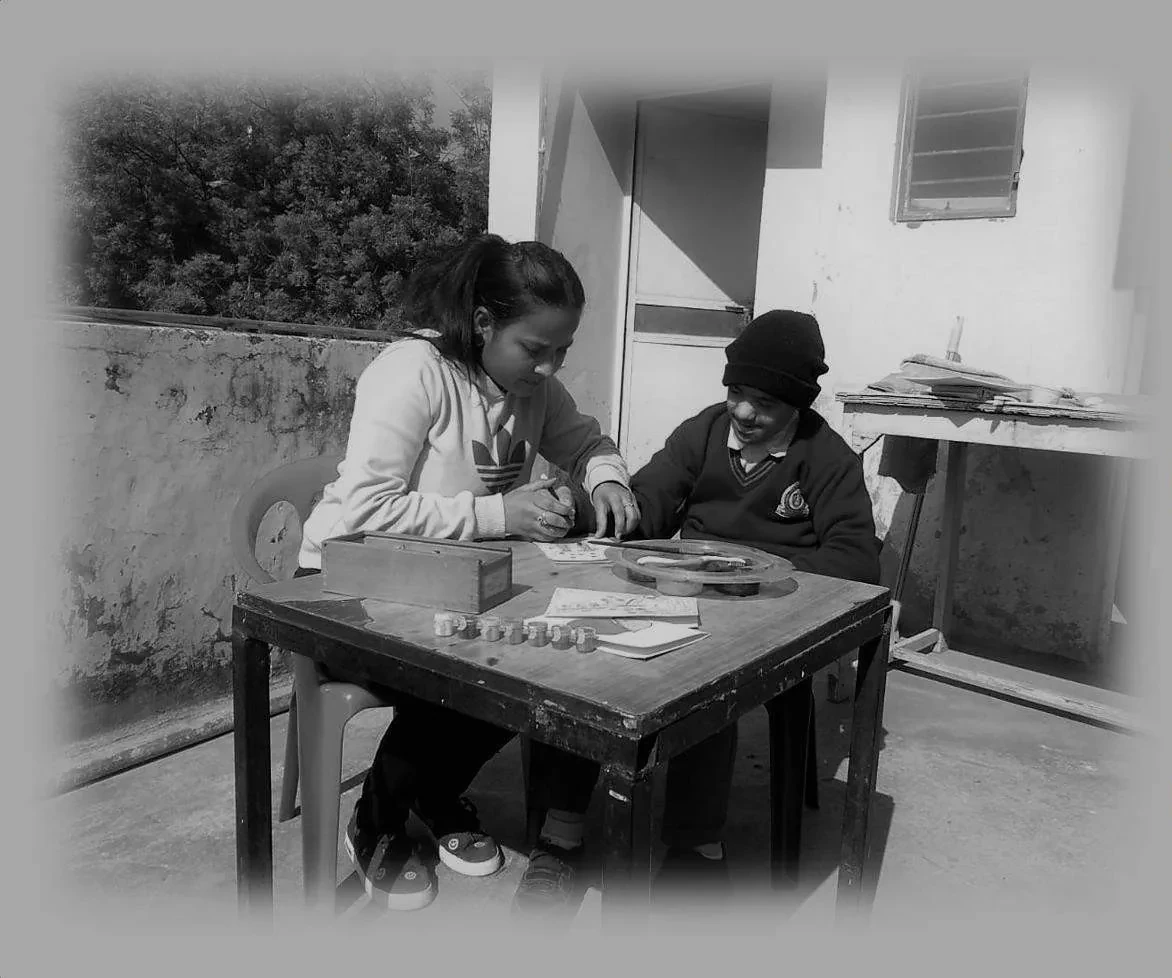 A therapist and a child working together at a table outdoors